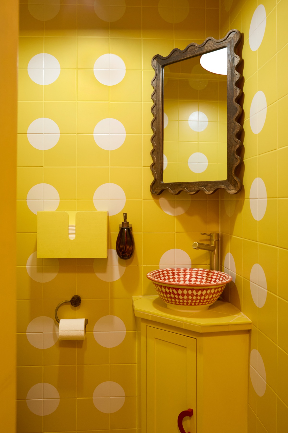 Playful yellow polka dot bathroom with red checkered basin