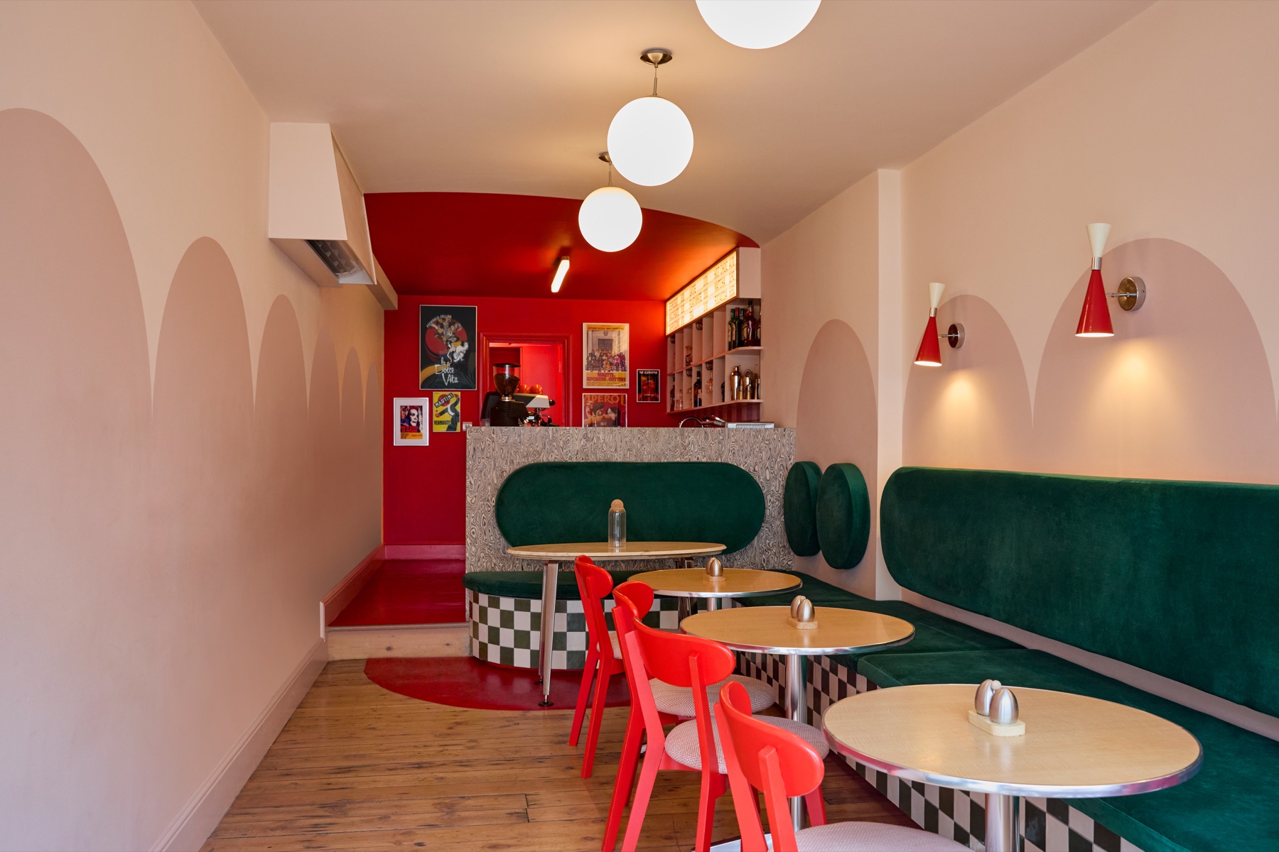 INTERVALLO dining room with red chairs, green banquette and arched walls